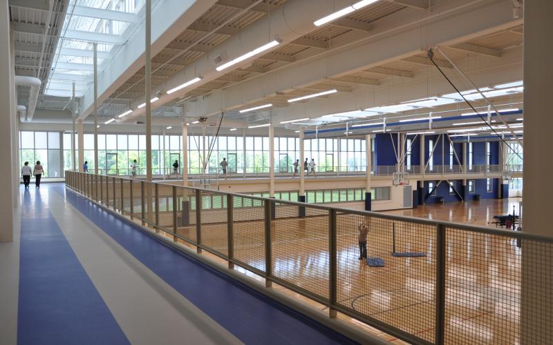 The new running track circles the new gym, the existing track was extended by 200 feet, resurfaced, and corners were rounded